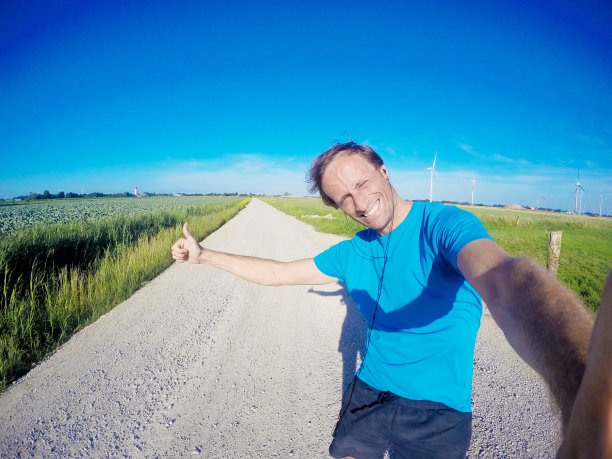 在尘土飞扬的路上快乐的慢跑者，GoPro图像图片下载