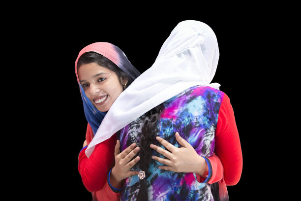 两个快乐的穆斯林妇女在开斋节互相拥抱。图片下载