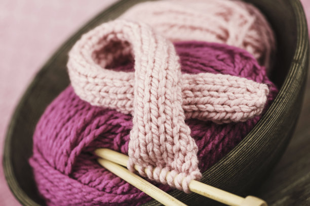 用针织针和羊毛编织乳腺癌意识丝带图片下载