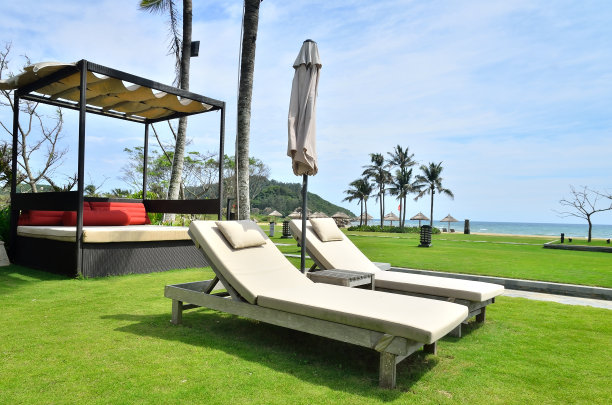 热带度假酒店草坪上的空日光浴床图片下载