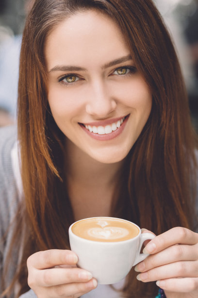 拿着一杯咖啡微笑着的女人图片下载