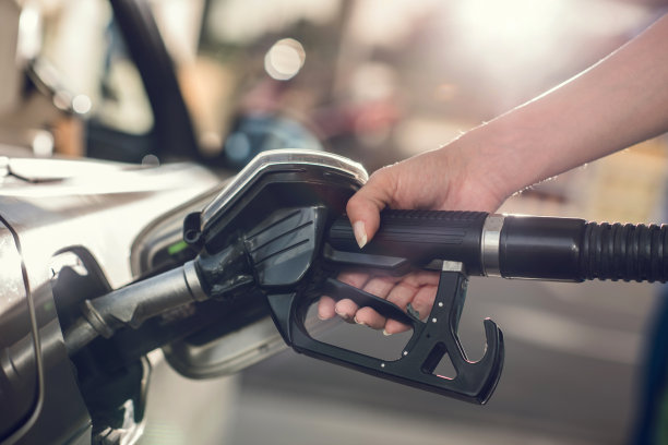 不认识的人往油箱加油。素材图片