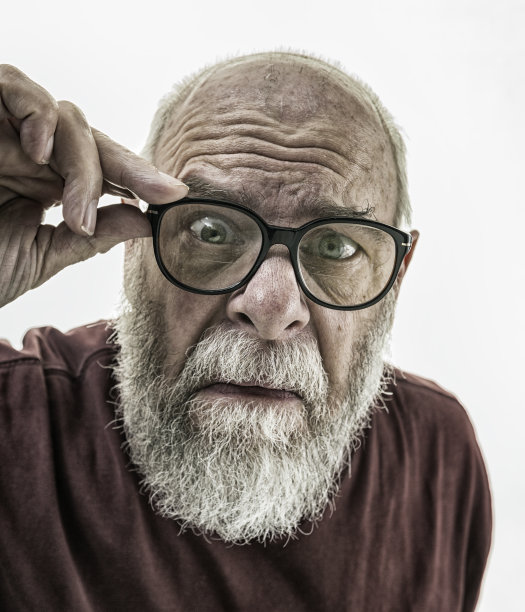 透过牛角边缘眼镜凝视的脏兮兮的皮肤老者图片下载