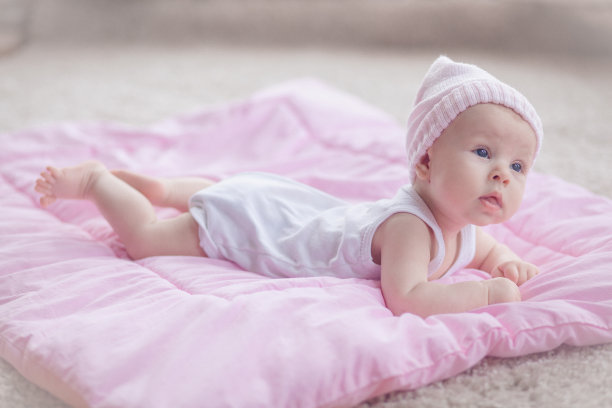 可爱的小女孩躺在她的肚子上，看起来很好奇图片下载