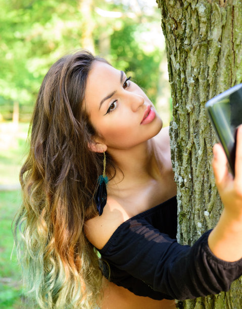 一个年轻女子在树林里自拍图片下载