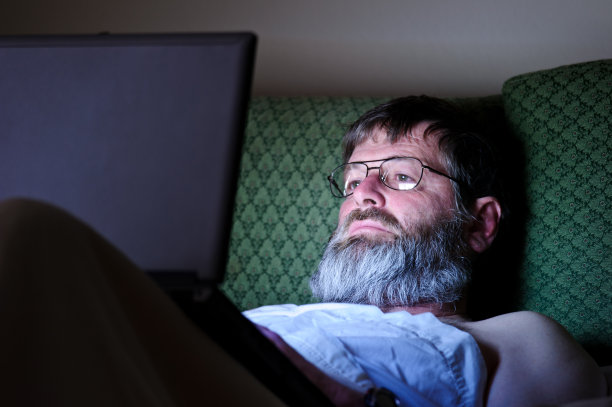 人们在黑暗的旅馆房间里用电脑工作图片下载