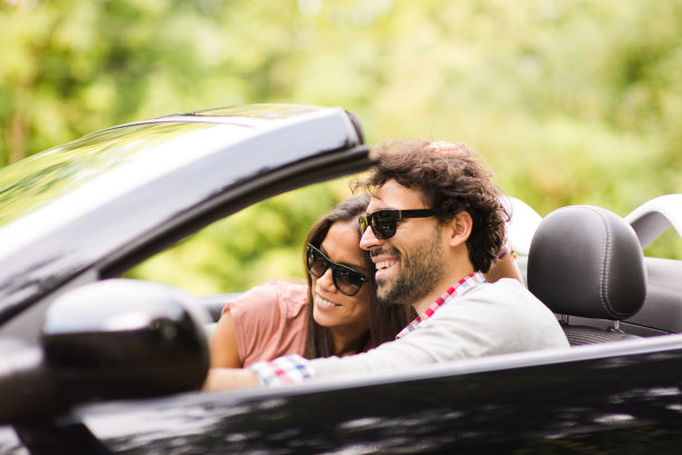 年轻的恋人对着一辆豪华轿车微笑图片下载