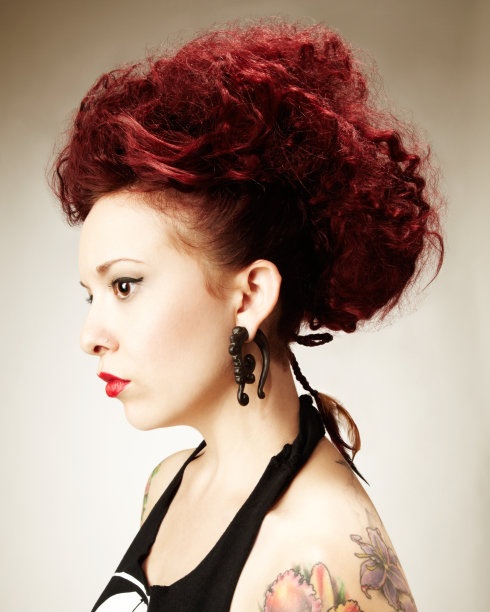 年轻红发女人的侧面与纹身和部落珠宝图片下载