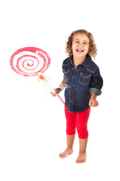 拿着巨型工艺棒棒糖的大笑的学龄前女孩图片下载