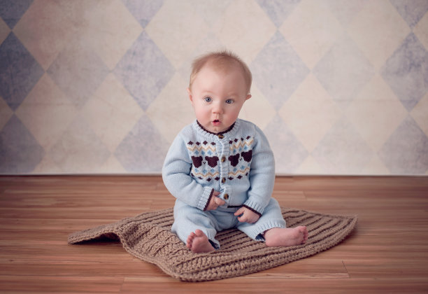 小男孩坐在编织毯子上图片下载