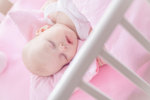 可爱的小女孩睡在白色的小床上图片下载