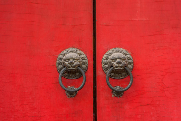 红色木门上的古狮子门环图片下载