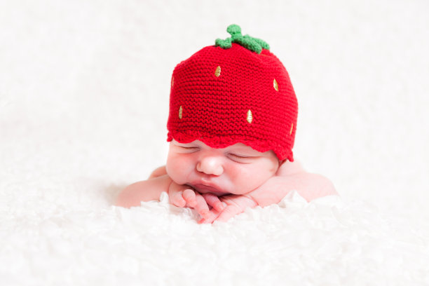 睡眼惺忪的白种新生儿双手抱着下巴图片下载