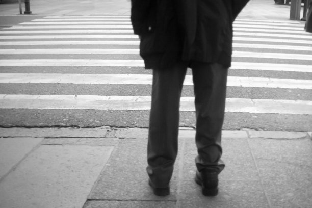 在人行横道上等待的男人的后视图。图片下载