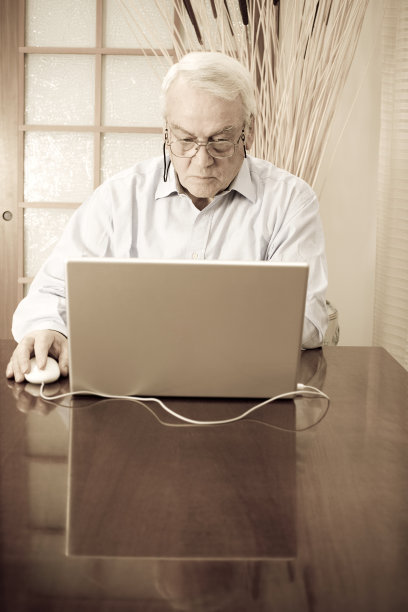 一个在家里用笔记本电脑工作的老人图片下载
