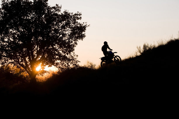 日落时分的越野摩托车手图片下载