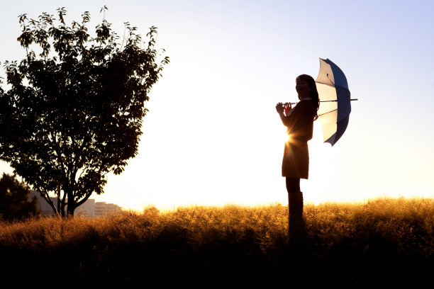 在地平线上拿着阳伞的女人图片下载