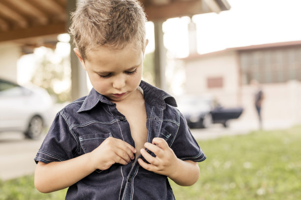 小男孩扣衬衫图片下载