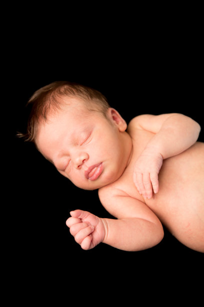 新生儿睡眠的彩色图像，黑色背景图片下载