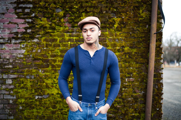 老砖墙旁边的少数民族男性图片下载