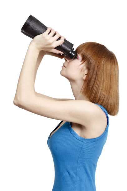 一个年轻女子用双筒望远镜仰望天空图片下载