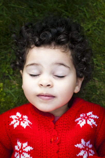 婴儿的肖像(2-3)躺在草地上。图片下载