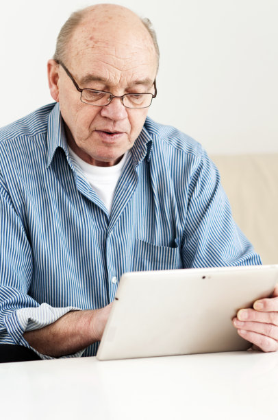 老人正在小心翼翼地玩着数码平板电脑图片下载