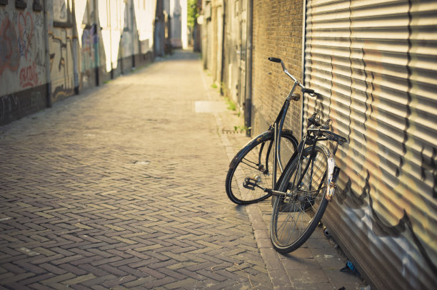 荷兰代尔夫特，一辆倚靠在墙上的废弃旧自行车图片下载