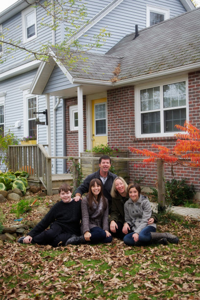 可爱的夫妇和十几岁的孩子与美丽的家在秋天图片下载