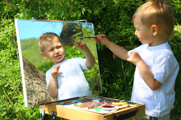 男孩艺术家在镜子上画画图片下载