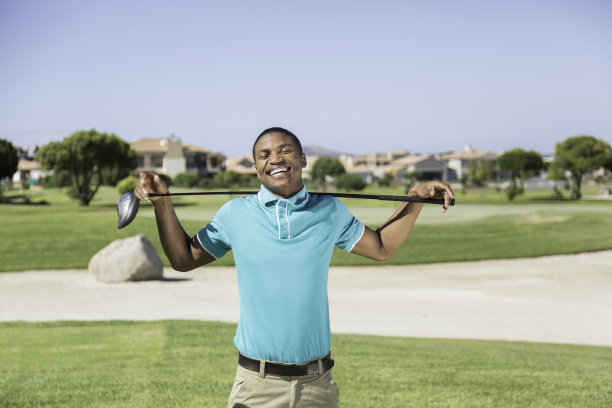 非洲年轻的高尔夫球手拿着他的球杆看着镜头图片下载