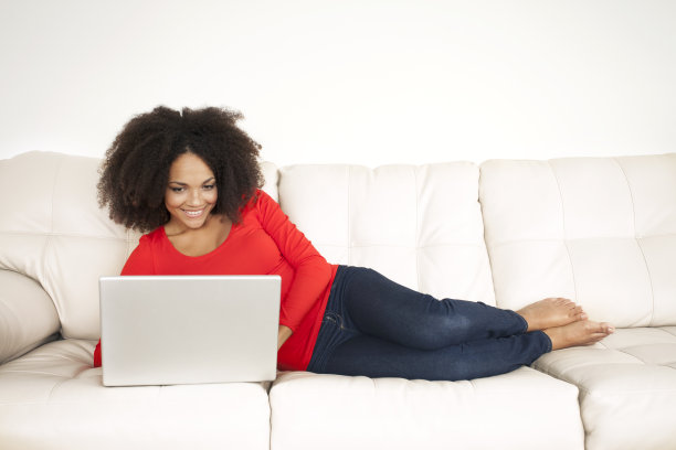 躺在沙发上用白色笔记本电脑的女人图片下载