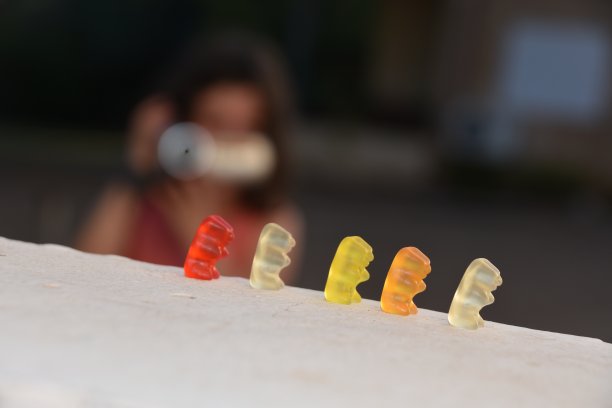 小女孩用摄像头拍小熊软糖图片下载