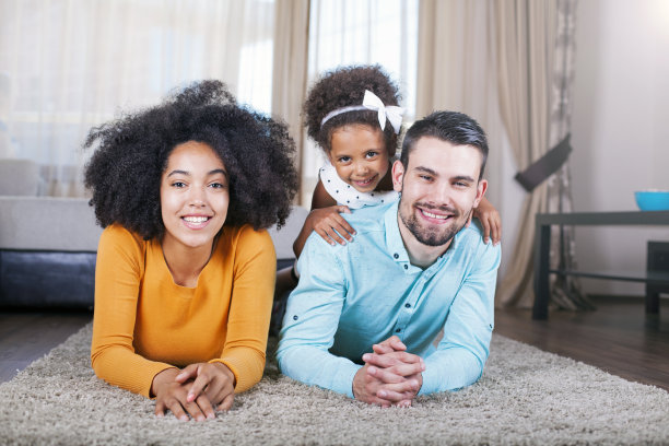 一家人躺在地毯上，微笑着图片下载
