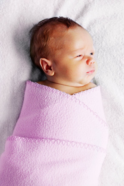 新生的小公主裹着粉红色的毯子，审视着她的王国图片下载