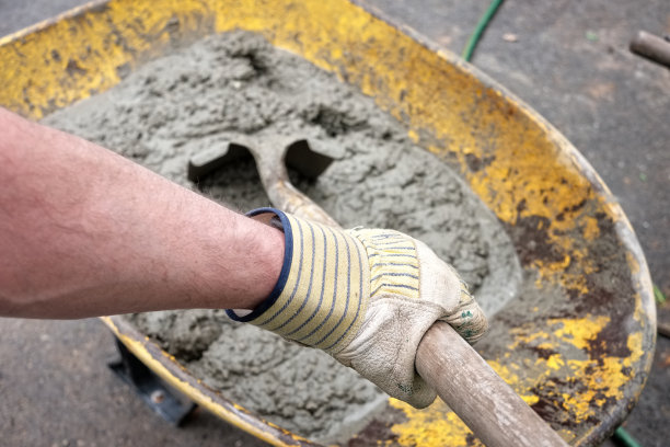 观点:用铲子在手推车里搅拌水泥的人图片下载