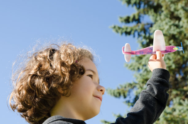 小女孩在玩玩具飞机图片下载