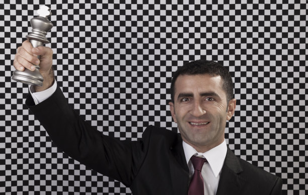 获胜的商人拿着棋王奖杯图片下载