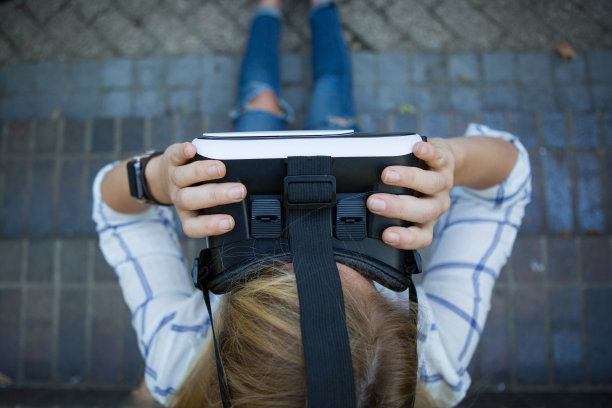 一个女人拿着虚拟现实眼镜的特写图片下载