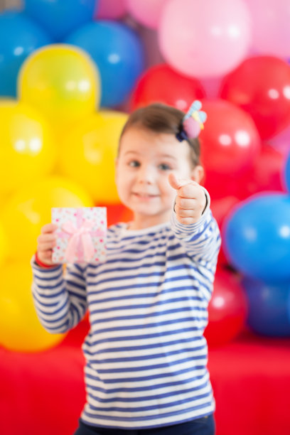 快乐的3岁女孩拿着小礼盒图片下载