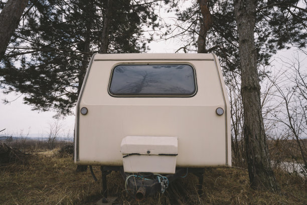 老旧的露营车停在树林里。低角度的观点。图片下载