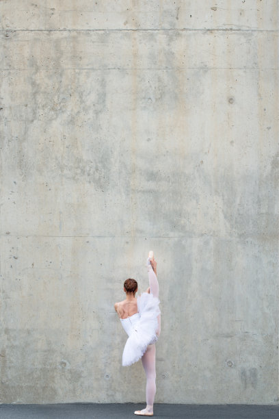 美丽的古典芭蕾舞者在混凝土前摆姿势图片下载