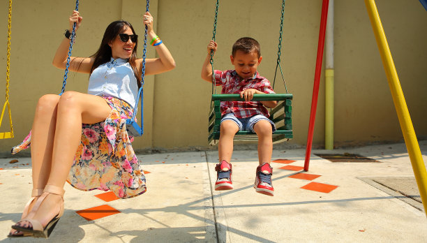 母亲和孩子在操场上享受秋千图片下载