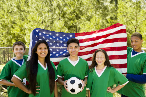 运动:青少年朋友足球队与美国国旗背景。图片下载