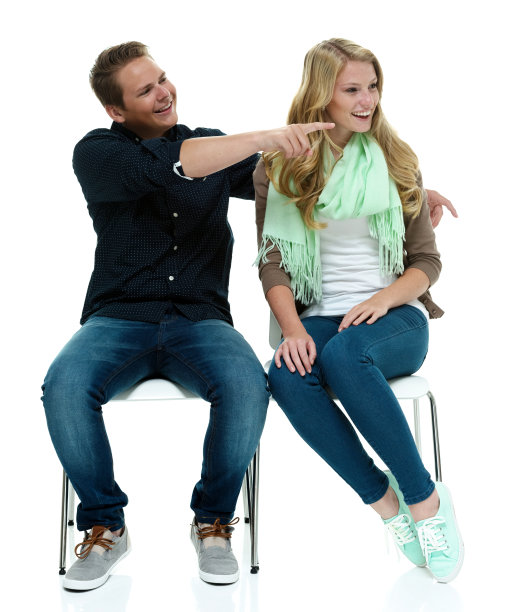 一对愉快的夫妇坐在椅子上，指着别处图片下载