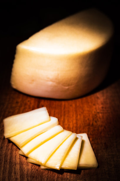黄色的奶酪，部分豪达干酪在古老的木头背景上图片下载