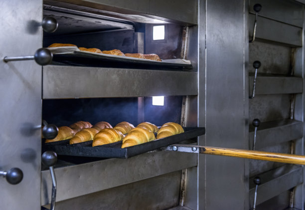 面包师从烤箱中取出面包图片下载