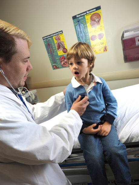 在医院和小男孩一起工作的医生图片下载