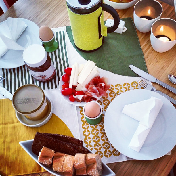 早餐桌上整齐地摆放着面包、鸡蛋、蜡烛、咖啡、奶酪图片下载