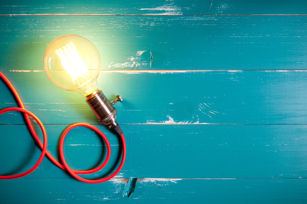 古董白炽灯爱迪生型灯泡在绿松石木桌素材图片